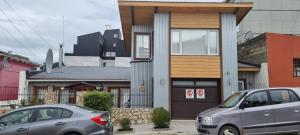 twee auto's geparkeerd voor een huis bij Estudio in Ushuaia