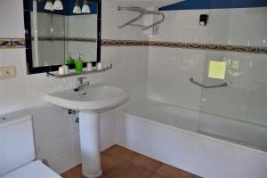 a white bathroom with a sink and a bath tub at Hostal Infanta Doña Leonor in Palencia