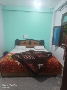 een slaapkamer met een bed met een deken erop bij Gold star guest house and cafe in Tosh