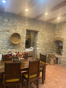 uma sala de jantar com uma mesa e uma parede de pedra em Il Casolare em Cantalupo nel Sannio
