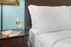 un bicchiere di vino su un tavolo accanto al letto di Top Notch Inn a Gorham
