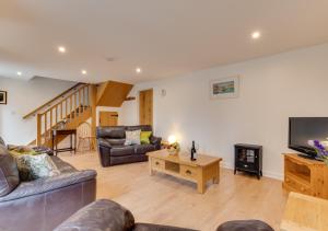 a living room with a couch and a tv at Bowgie in Saint Merryn