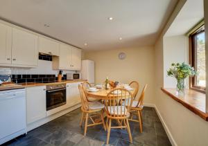a kitchen with a table and chairs and a counter at Bowgie in Saint Merryn