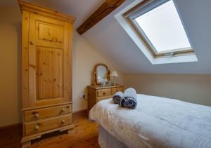 1 dormitorio con 1 cama con tocador y ventana en Carnedd Llywelyn, en Llanrwst