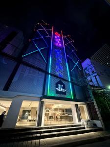 a building with blue and green lights on it at Grace At Five by Grace Hotel Bangkok in Bangkok