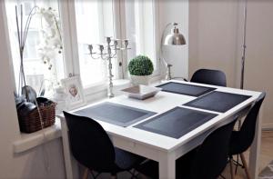 a white dining room table with black chairs and a window at Scandinavian Home 21 in Heard City in Helsinki