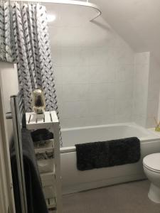 y baño con bañera y aseo. en Comfortable rooms with live in host, walking distance to the High St & more en Glastonbury