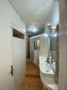 a white bathroom with a sink and a mirror at Piso delante de la playa La Pineda con 2 habitaciones in La Pineda