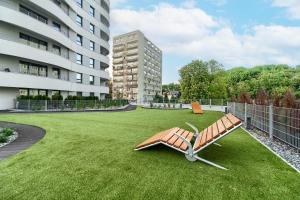 a bench on the grass in the middle of a building at Apartments Ostsee Suntowers in Świnoujście