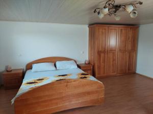 1 dormitorio con cama de madera y armario de madera en Sunflower House with Jacuzzy and Sauna, en Vitanje