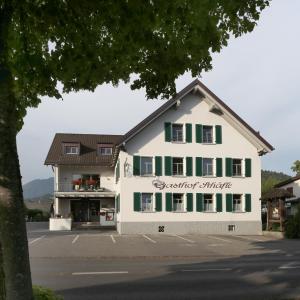 un grande edificio bianco con persiane verdi di Schäfle Landgasthof a Feldkirch