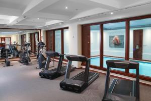 a gym with several treadmills and a swimming pool at Courtyard by Marriott Tbilisi in Tbilisi City