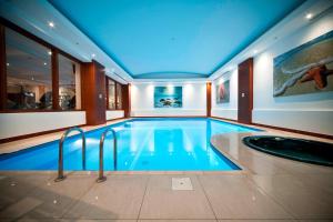 uma piscina num hotel com tecto azul em Courtyard by Marriott Tbilisi em Tbilisi