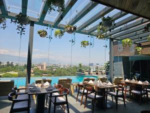 カトマンズにあるHotel Barahi Kathmanduのテーブルと椅子のあるレストラン、プールを提供しています。