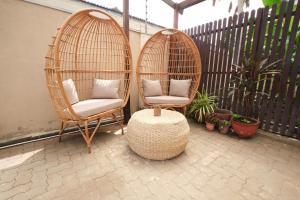 two wicker chairs and a table on a patio at The Avery at Windsor Apartments, Osu in Accra