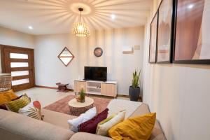 a living room with a couch and a tv at The Avery at Windsor Apartments, Osu in Accra