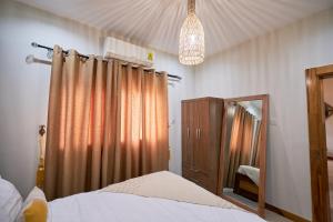 a bedroom with a bed and a dresser and a mirror at The Avery at Windsor Apartments, Osu in Accra