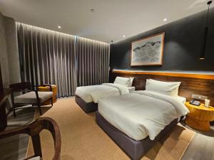 Hotel Barahi Kathmandu في كاتماندو: غرفة فندقية بسريرين وكرسي