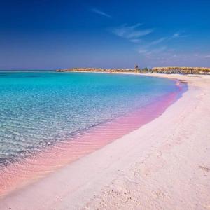 a beach with pink sand and the blue water at heaven suite elafonisi in Elafonisi