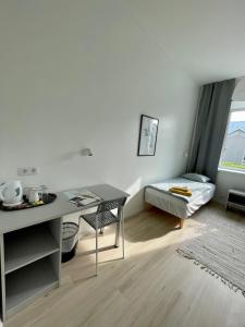 Zimmer mit einem Schreibtisch, einem Tisch und einem Bett in der Unterkunft Endla Hostel ja Apartamendid in Haapsalu