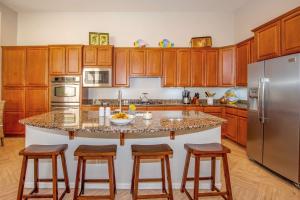 a kitchen with wooden cabinets and a large island with bar stools at Phoenix Vacation Rental Near Golf and Shopping in Phoenix