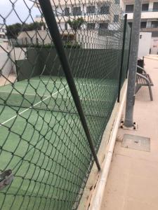 una pista de tenis detrás de una valla de eslabones en Garrucha en Garrucha