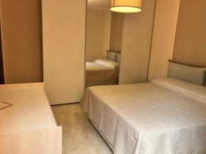 um pequeno quarto com 2 camas e um espelho em La casa dell'Asparago em Messina