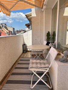 einen Balkon mit einem Tisch und einem Stuhl auf einer Terrasse in der Unterkunft Dockview atelier in Burgas City