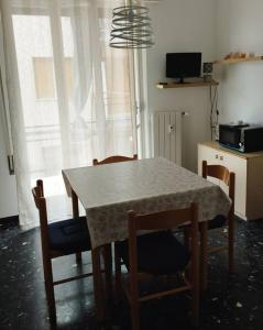 - une table à manger et des chaises dans une pièce avec fenêtre dans l'établissement LOANO MARE, à Loano