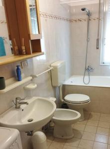 uma casa de banho branca com um WC e um lavatório em LOANO MARE em Loano