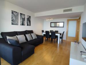 a living room with a black couch and a table at Apartment Airport Barcelona Premium in Viladecáns