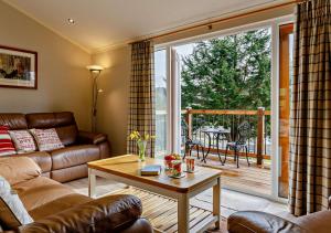 uma sala de estar com um sofá e uma mesa em Meadow Lodge - Cornwall em Cardinham