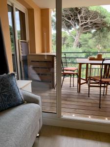 a screened in porch with a couch and a table at LA BADINE 5p Plage piscine clim jacuzzi parc luxuriant in Hyères