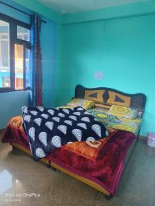 een bed in een kamer met een blauwe muur bij Gold star guest house and cafe in Tosh