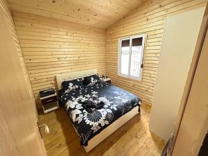ein Schlafzimmer mit einem Bett in einer Holzhütte in der Unterkunft Speakeasy Lux 3 - 4 in Ulcinj