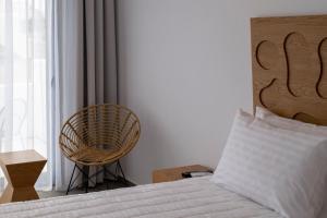 1 dormitorio con 1 cama y 1 silla junto a una ventana en Giannoulaki Resort, en Glastros