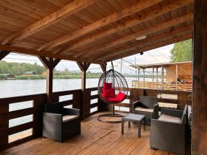 eine Veranda mit Stühlen und einer Schaukel auf einem Boot in der Unterkunft Speakeasy Lux 3 - 4 in Ulcinj