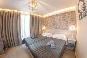 a bedroom with a large bed with towels on it at Jasmine Hotel & Apartments in Agios Stefanos