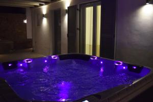 una vasca idromassaggio con luci viola in una stanza di Giannoulaki Resort a Glastros