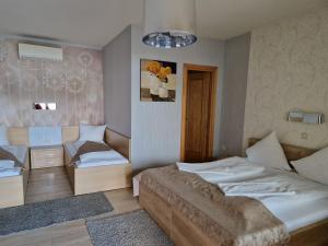 een slaapkamer met 2 bedden, een tafel en een raam bij Csalánosi Vendégház in Kecskemét