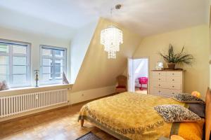 a bedroom with a bed and windows and a chandelier at Ferienwohnung Saline in Bad Wildbad
