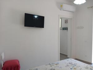 a room with a tv on a white wall at Da Raff house in Lacco Ameno