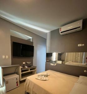 um quarto de hotel com uma cama e uma televisão em TERESINA HOTEL em Teresina