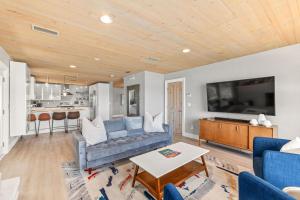 sala de estar con sofá azul y cocina en Marsh Front Birders Paradise Close to Beaches and Downtown, en St. Augustine