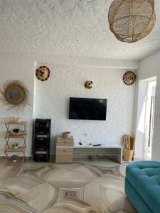 sala de estar con TV en una pared blanca en Maison cabo negro pied dans l’eau en Cabo Negro