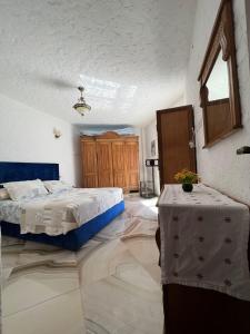 1 dormitorio con 2 camas y 2 mesas. en Maison cabo negro pied dans l’eau en Cabo Negro