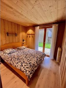 a bedroom with a bed and a large window at Résidences Delavay La Cordée in Les Gets