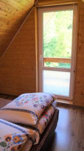 2 camas en una habitación con ventana grande en Gospodarstwo Agroturystyczne Na Górce Domek 1, en Myczkowce