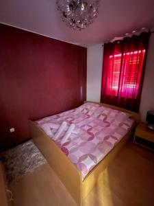 um quarto com uma cama com lençóis cor-de-rosa e uma janela em Lucasso em Povljana