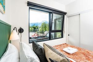 a bedroom with a bed and a window with a view at The Ski Shanty by Revelstoke Vacations in Revelstoke
